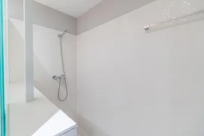 a shower in a white bathroom with a glass door at Casa Majestic in Cunit