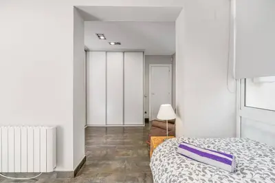 a bedroom with a bed with a purple pillow on it at Beachside Bliss in Castelldefels