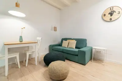 a living room with a blue couch and a table at Amazing flat in Barceloneta with private terrace 2-2 in Barcelona