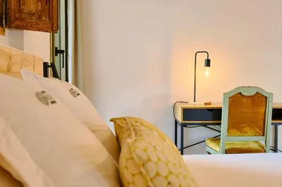 a bedroom with a bed with a desk and a chair at Hotel Molí Cardedeu in Cardedeu