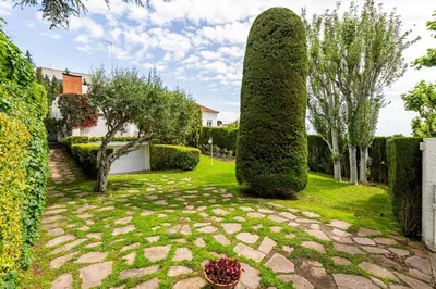 a garden with a large bush in the yard at Casa Mediterránea con jardín y piscina privada in Masnou