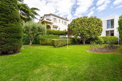 a house with a yard with green grass and trees at Casa Mediterránea con jardín y piscina privada in Masnou