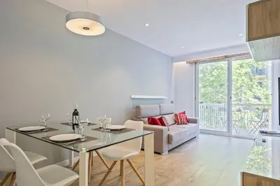 a kitchen and living room with a table and chairs at Habitat Apartments Pau in Barcelona