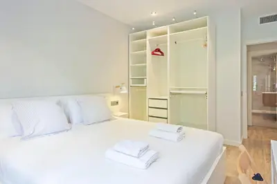 a bedroom with a white bed with towels on it at Habitat Apartments Pau in Barcelona