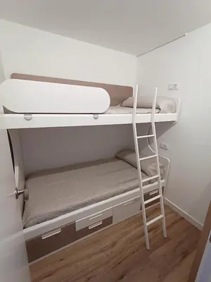 a bunk bed with a ladder in a room at Apartamento nuevo en Calella totalmente reformado con Parking privado in Calella