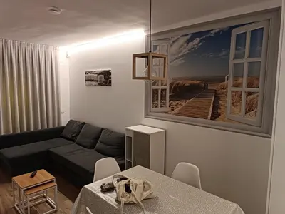 a living room with a couch and a picture of a beach at Apartamento nuevo en Calella totalmente reformado con Parking privado in Calella