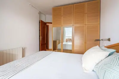 a bedroom with a white bed and a large closet at Sunset oceanfront in Castelldefels