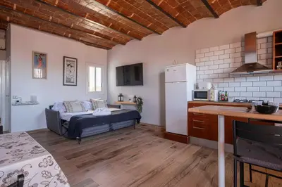 a living room with a bed and a kitchen at Atico con Terraza en Fira Barcelona - Negocios y Turismo en Sants - Montjuic in Barcelona
