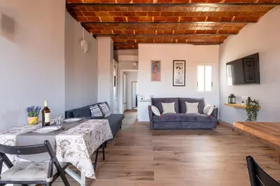 a living room with a table and a couch at Atico con Terraza en Fira Barcelona - Negocios y Turismo en Sants - Montjuic in Barcelona