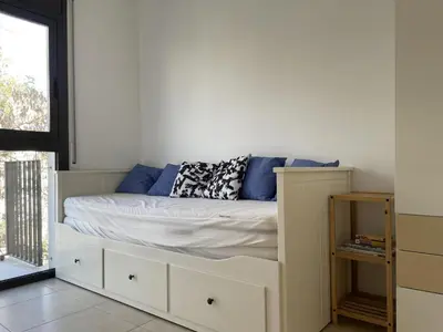 a bed with blue pillows on it in a room at Apartment Marina in Vilanova i la Geltrú