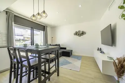 a dining room with a table and chairs in a living room at HomeHolidaysRentals Kala - Costa Barcelona in Pineda de Mar