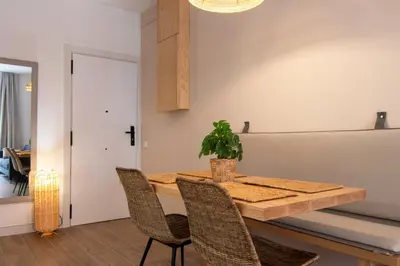 a dining room table with chairs and a potted plant at Stay U-nique Apartment Comte Güell in Barcelona