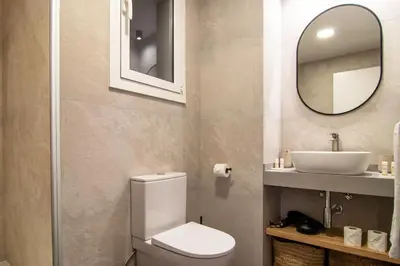 a bathroom with a toilet and a sink and a mirror at Stay U-nique Apartment Comte Güell in Barcelona