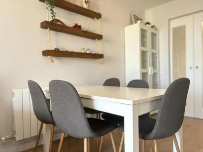 a dining room with a white table and chairs at Golden hours by the sea in Castelldefels