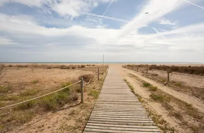 a wooden path in the middle of the beach at Golden hours by the sea in Castelldefels