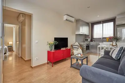 a living room with a blue couch and a kitchen at BBarcelona Urban Apartments in Barcelona