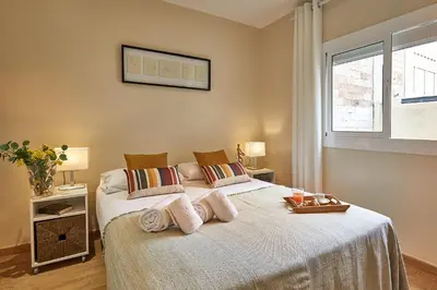 a bedroom with a large bed with towels on it at BBarcelona Urban Apartments in Barcelona