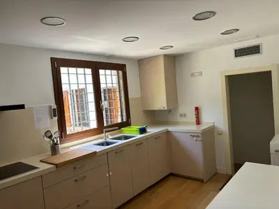 a kitchen with white cabinets and a sink and a window at Vivenda de luxe a Barcelona in Sant Cugat del Vallès
