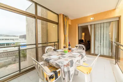a dining room with a table and chairs and a balcony at Apartamento Acqua Fresca in Cunit