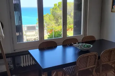 a dining room table with chairs and a view of the ocean at Casa perfecta con vistas al Mar in San Pol de Mar