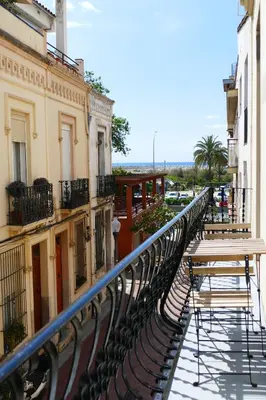a balcony with a table and benches on a building at La Llar de la Kim, ideal familias in Arenys de Mar