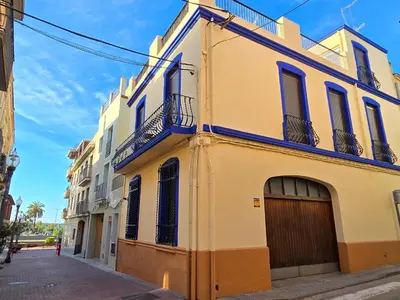 a yellow building with a garage on a street at La Llar de la Kim, ideal familias in Arenys de Mar