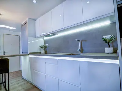 a kitchen with white cabinets and a sink at Urban Waves by Hello Homes Sitges in Sitges