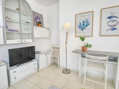 a living room with a desk and a tv at Llopart Apartment by Hello Homes Sitges in Sitges