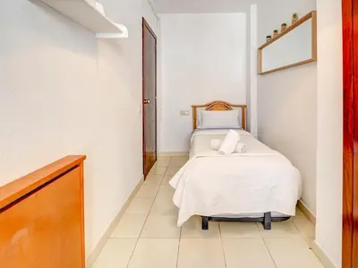 a bedroom with a bed in a white room at Llopart Apartment by Hello Homes Sitges in Sitges