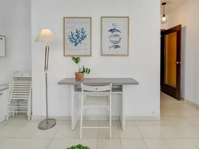 a white dining room with a table and chairs at Llopart Apartment by Hello Homes Sitges in Sitges