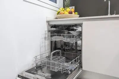 an open dishwasher with baskets of fruit in it at Canela Homes BARCELONA STYLE in Barcelona