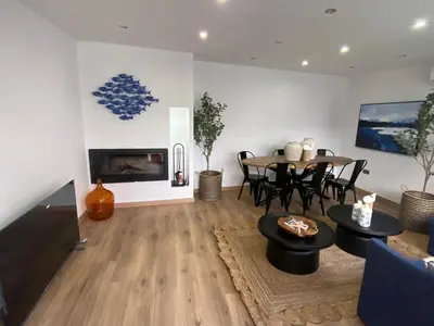 a living room with a fireplace and a table and chairs at Matarolux26 in Mataró