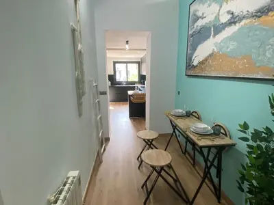 a hallway with a table and stools in a room at Matarolux26 in Mataró