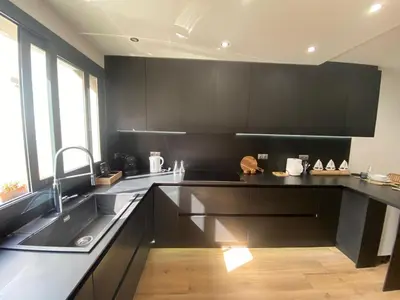 a kitchen with black cabinets and a sink at Matarolux26 in Mataró