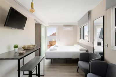 a bedroom with a bed and a table and chairs at Aparthotel Vilassar in Vilassar de Mar