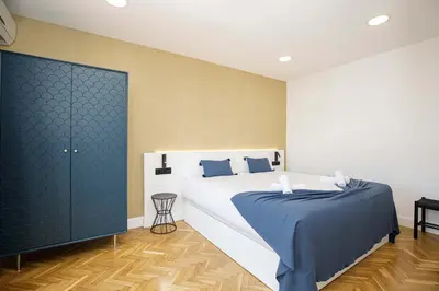 a bedroom with a large white bed and blue sheets at Stay U-nique Apartments Rambla Catalunya VI in Barcelona