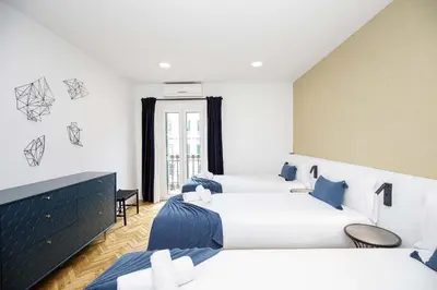 a hotel room with two beds and a window at Stay U-nique Apartments Rambla Catalunya VI in Barcelona