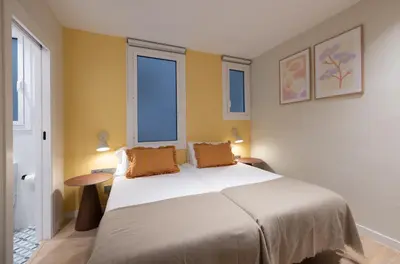 a bedroom with a large bed with two orange pillows at Stay U-nique Apartment Muntaner in Barcelona