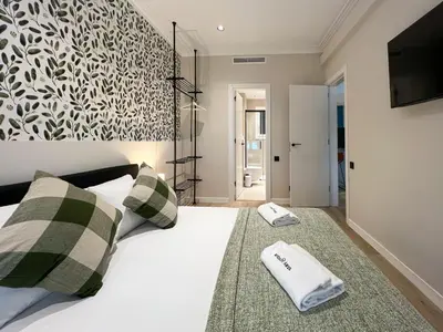 a bedroom with a large white bed with towels on it at Stay U-nique Apartment Muntaner in Barcelona