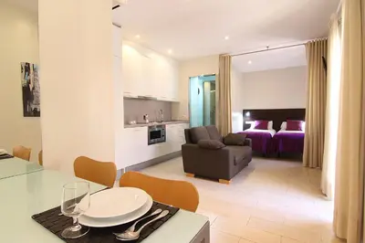 a kitchen and a living room with a couch and a table at ClassBedroom Barcelona Beach Apartments in Barcelona