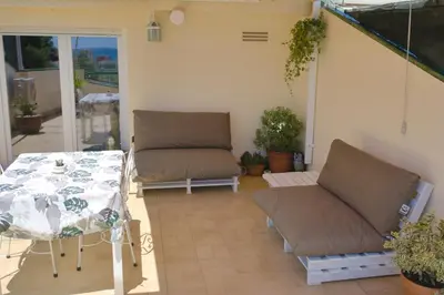 a patio with a table and a couch and a table and chairs at Apartamento Sunny Home in Cunit