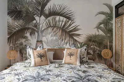 a bedroom with a bed with a mural of palm trees at OASIS BEACH-CITY apartment in Montgat