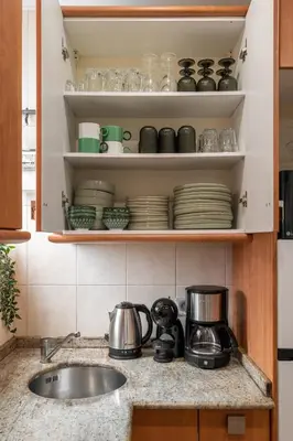 a kitchen counter with a sink and dishes on shelves at OASIS BEACH-CITY apartment in Montgat