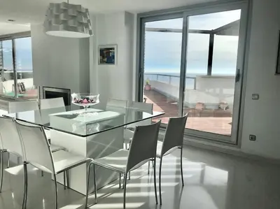 a dining room with a glass table and chairs at Sitges espectacular vista al mar in Sant Pere de Ribes