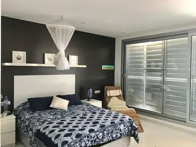 a bedroom with a bed and a large window at Sitges espectacular vista al mar in Sant Pere de Ribes