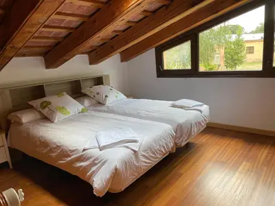 two beds in a room with two windows at Casa rural El Bruguer Vell in Santa Eulalia de Ronsaná