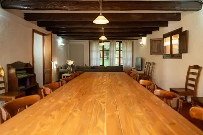 a large wooden table in a room with chairs at Casa rural El Bruguer Vell in Santa Eulalia de Ronsaná