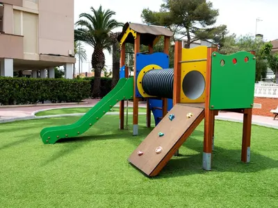 a playground with a slide on the grass at Apartment Garbi by Interhome in Cunit