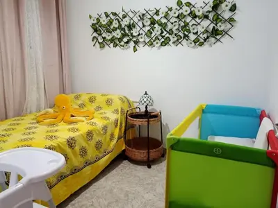 a room with a bed with a yellow toy on it at GARDEN'S SEA PiNEDA DE MAR in Pineda de Mar