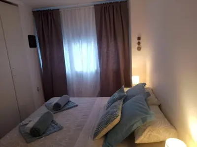 a bedroom with a bed with pillows and a window at Migjorn Apartment a place in the heart of Sitges in Sitges